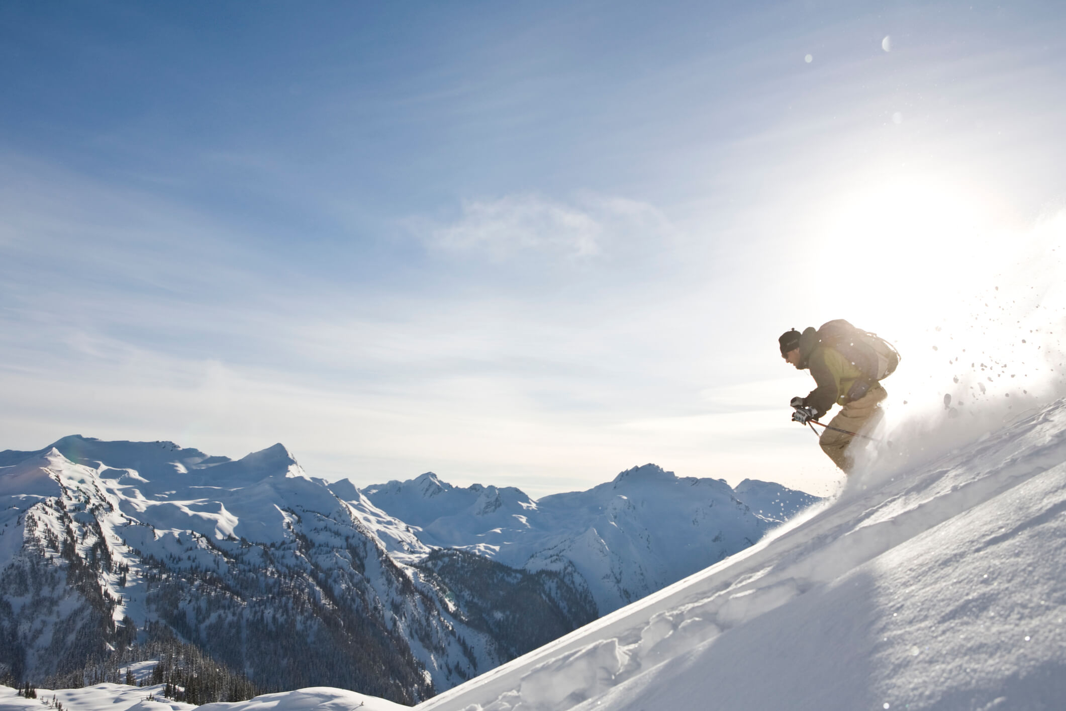 A solo skier descends down a mountain in the British Columbia backcountry.
