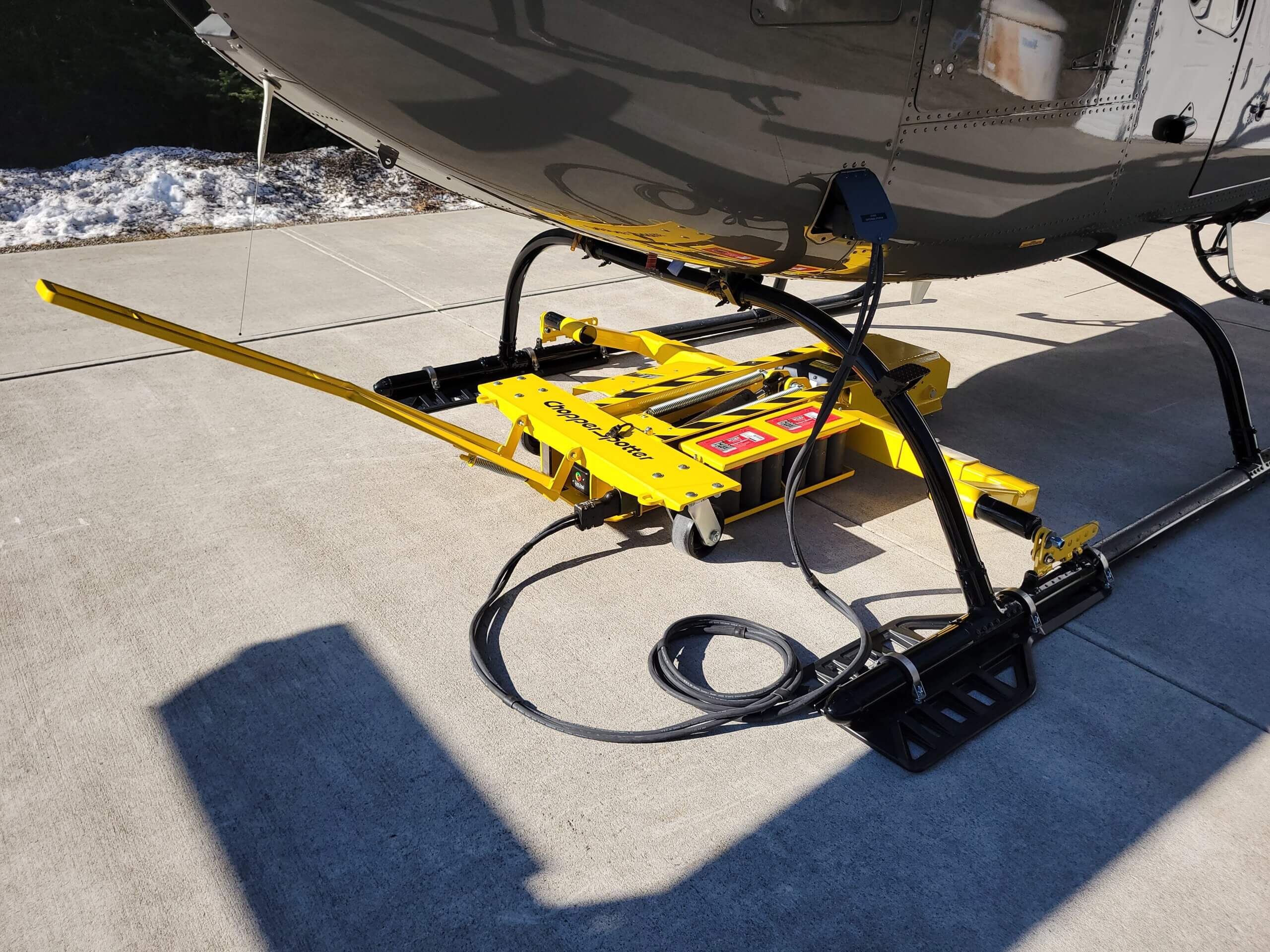 A Chopper Spotter ground handling unit providing power to a helicopter with its built-in ground power unit (GPU)