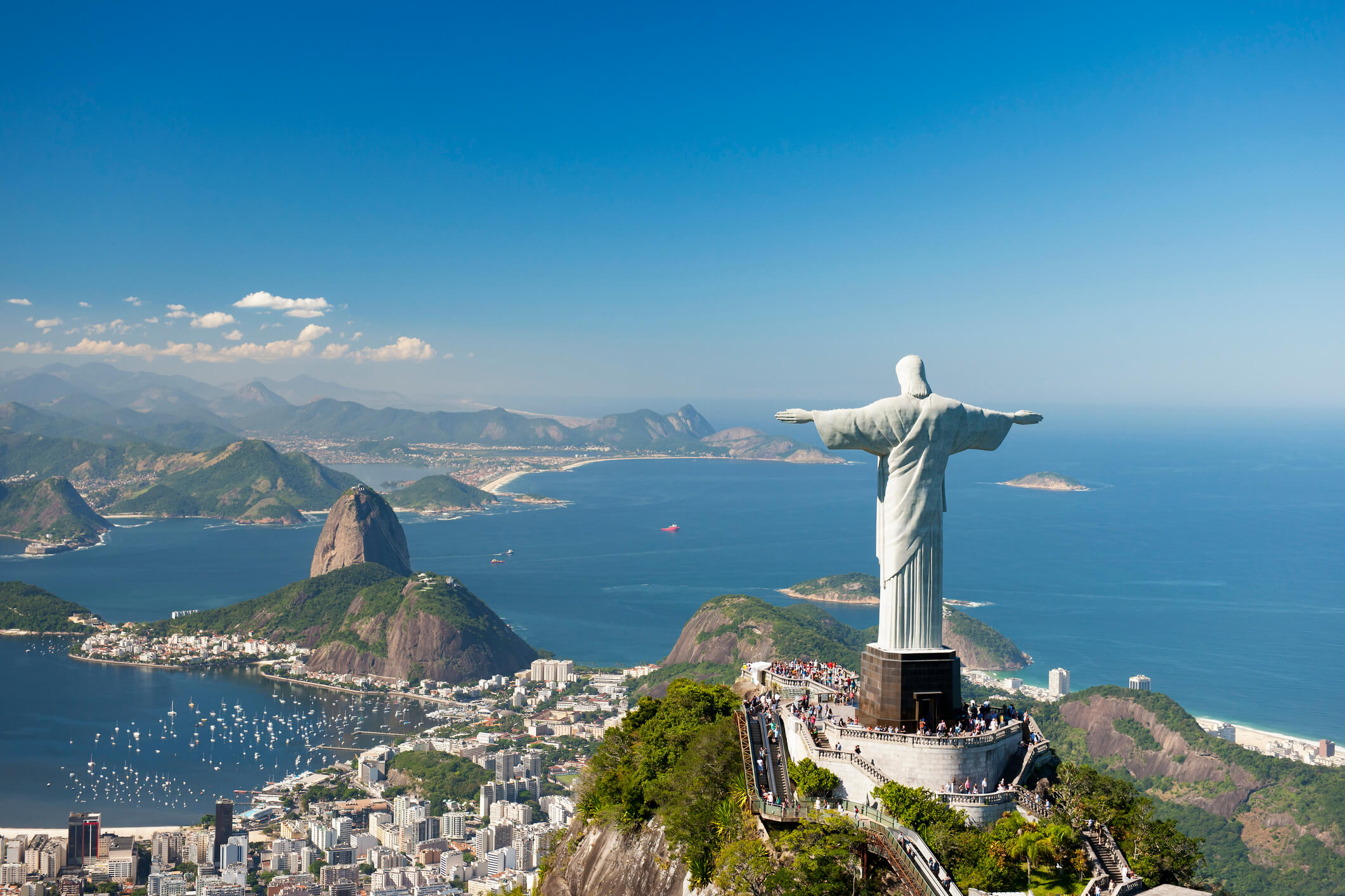 Aerial view of 'Christ The Redeemer' statue with Sugarloaf Mountain, Copacabana Beach and Botafogo Beach in the background.