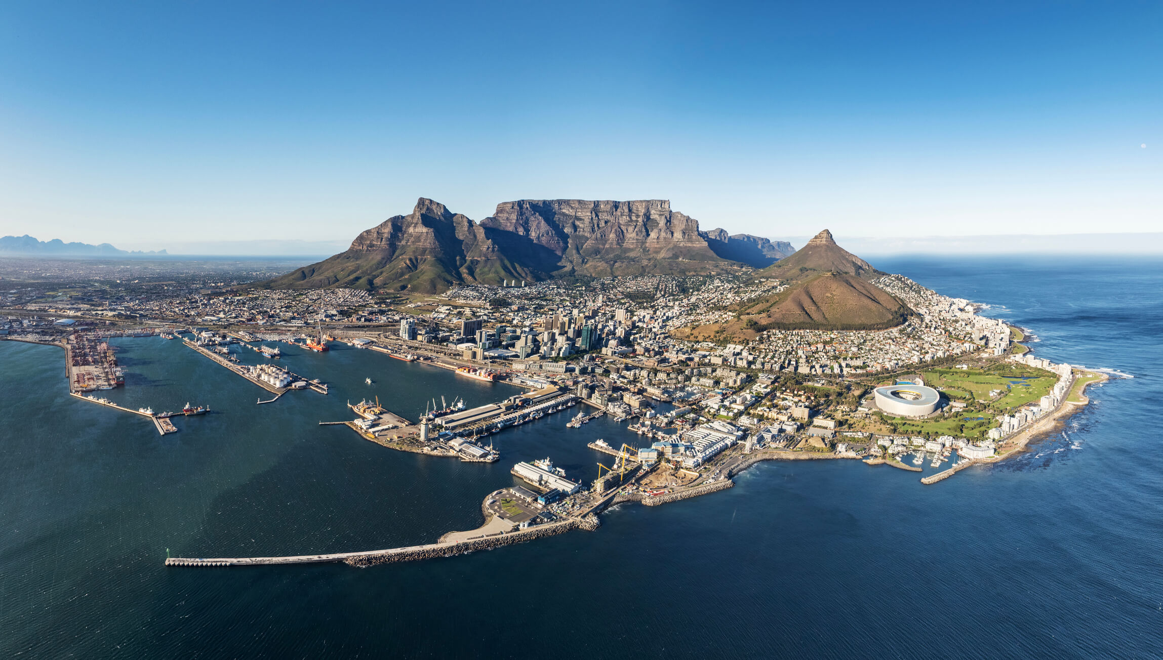 Breathtaking view of Cape Town, South Africa, with Table Mountain towering above the vibrant cityscape, surrounded by the Atlantic Ocean.  A bucket-list destination