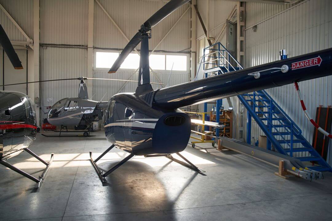 Two helicopters parked inside a hangar.